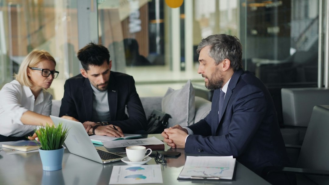 Business colleagues collaborating around a table with a laptop.